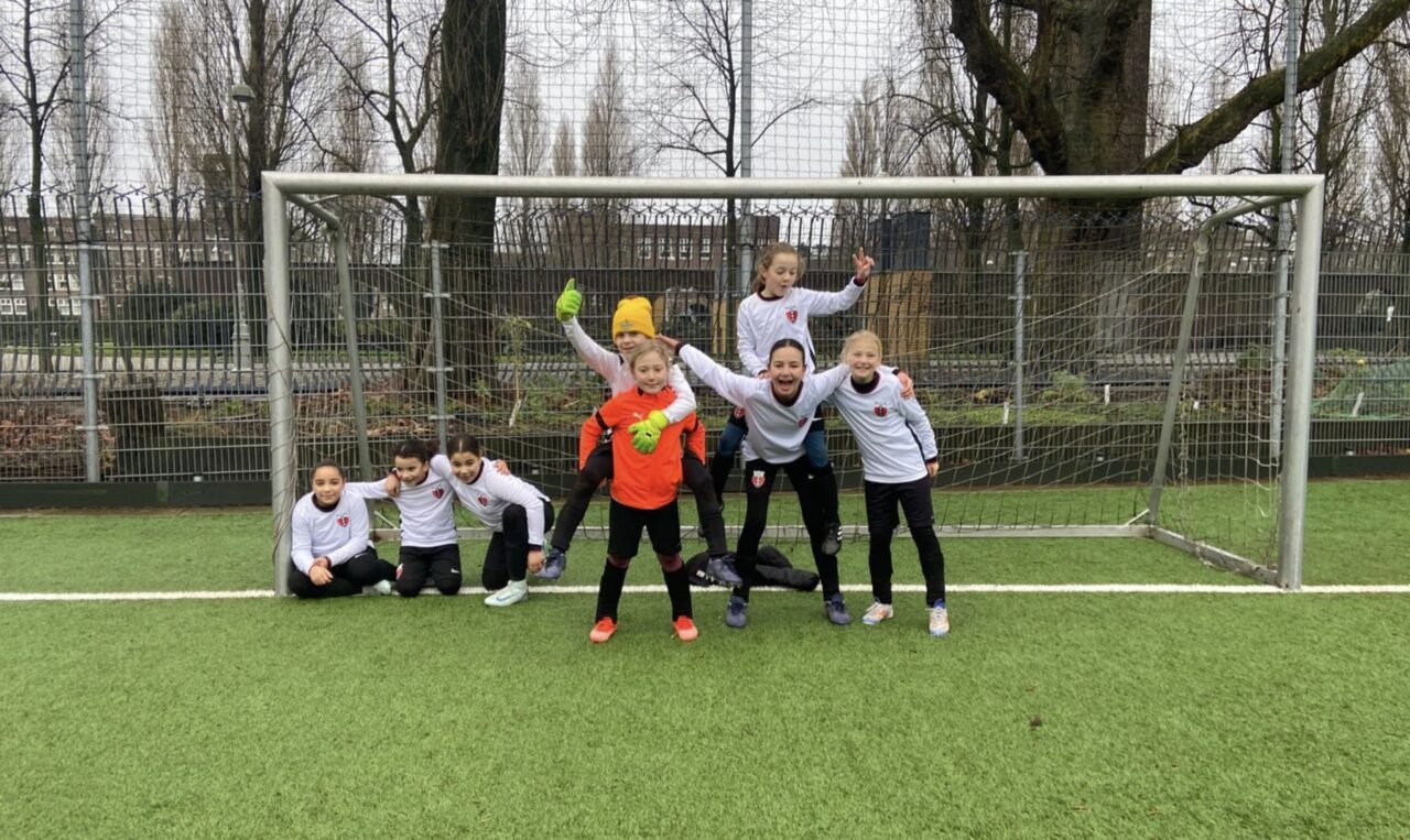 Speelsters van RAP MO12-1 poseren vrolijk voor het doel